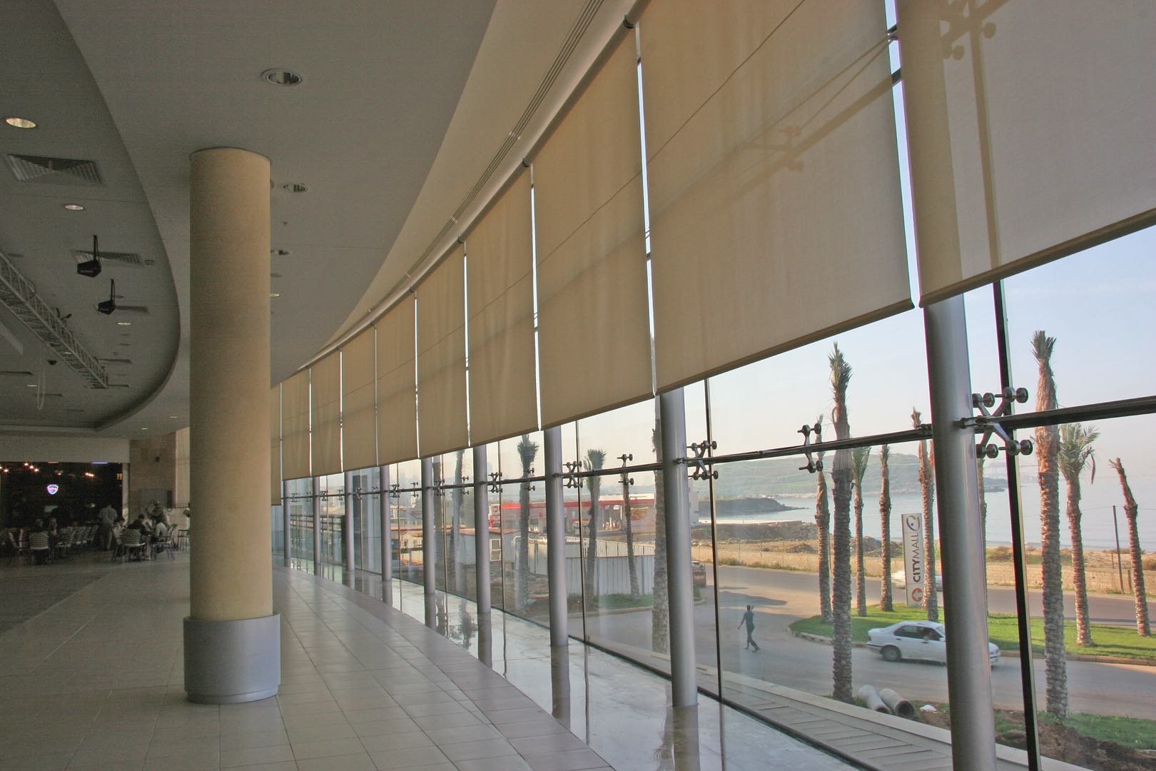 Roller blinds along a glazed gallery